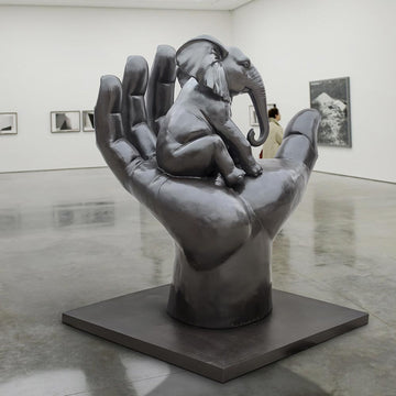 An Elephant in a Big Hand (Bronze Sculpture)