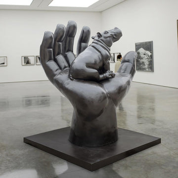 A Hippo in a Big Hand (Bronze Sculpture)